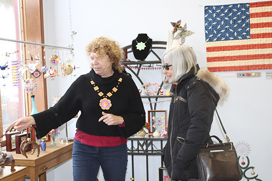 At her new shop, Alice Larson, left, shows some of her work to customer Pam Haulman. — Image Credit: Susan Riemer/Staff Photo